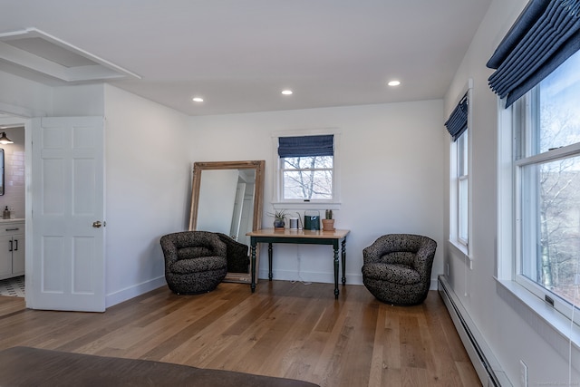 sitting room featuring hardwood / wood-style floors and a baseboard heating unit