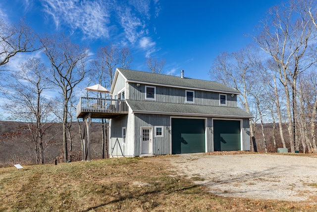 back of property with a garage and a wooden deck