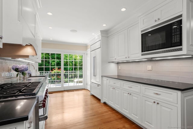 kitchen featuring sink, light hardwood / wood-style flooring, appliances with stainless steel finishes, white cabinets, and ornamental molding