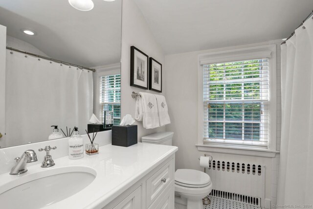 bathroom featuring vaulted ceiling, radiator, and a healthy amount of sunlight