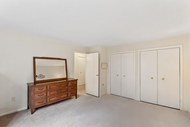 27 Crows Nest Ln Unit 15E, Danbury, CT 06810 - bedroom with two closets, baseboards, and light colored carpet