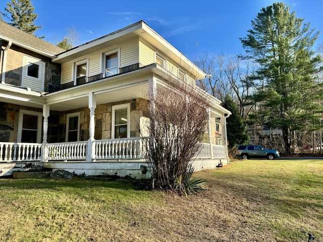 view of property exterior with a yard and a porch