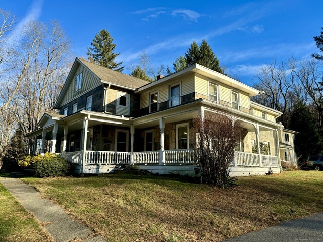 farmhouse inspired home with covered porch and a front yard