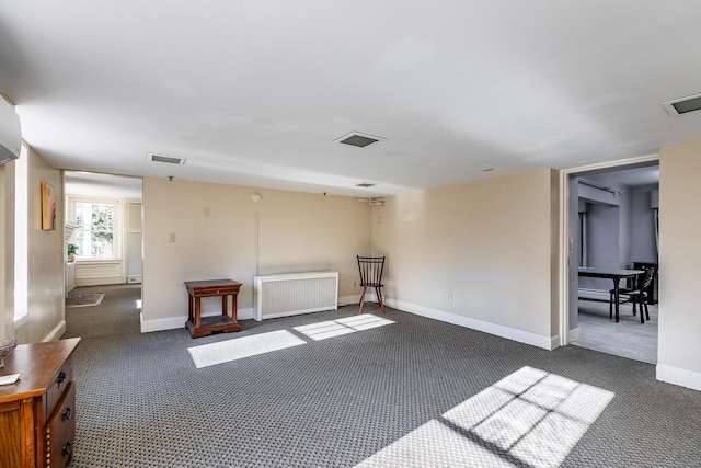 spare room with visible vents, baseboards, and dark colored carpet