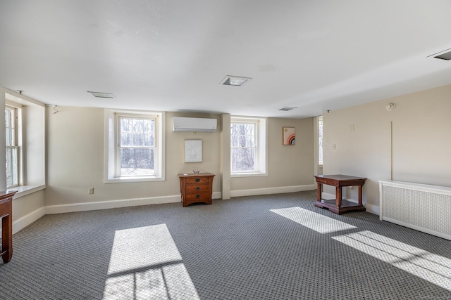 empty room with radiator, baseboards, a wall unit AC, and carpet floors