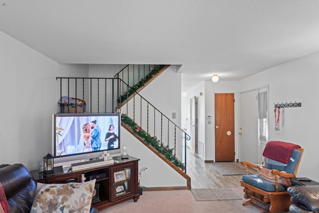 living room featuring light hardwood / wood-style floors and a textured ceiling