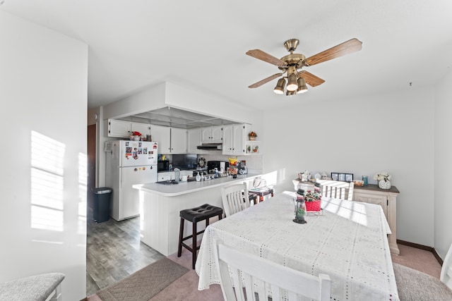 dining space featuring ceiling fan and light wood-type flooring