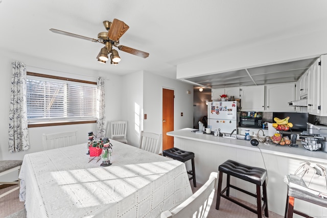 dining room featuring light carpet and ceiling fan