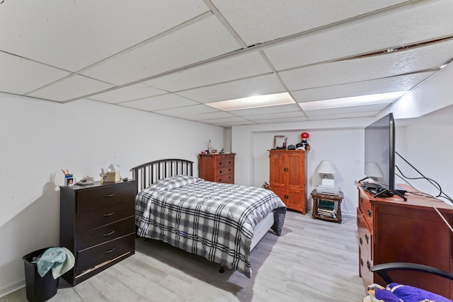 bedroom with light hardwood / wood-style flooring and a drop ceiling