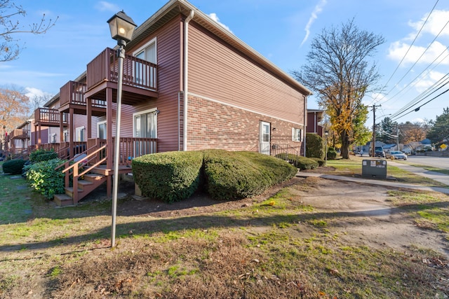 view of property exterior featuring a lawn and a balcony