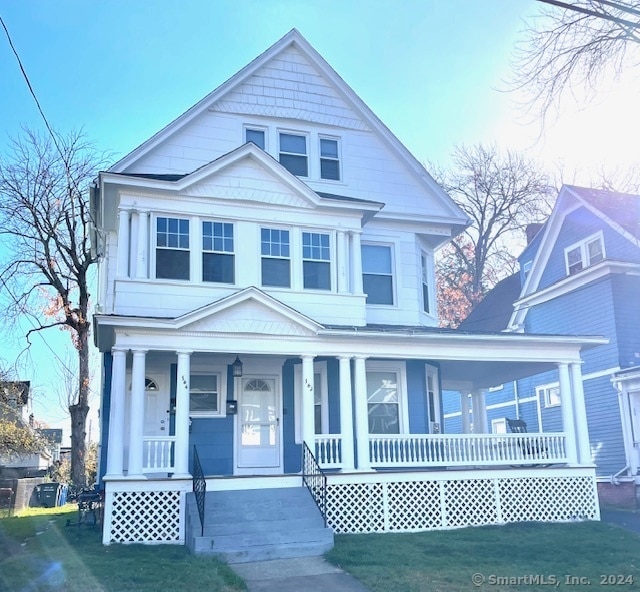 view of front of house with a porch and a front lawn