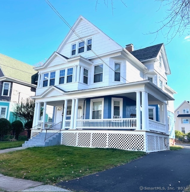 view of front facade featuring covered porch and a front lawn