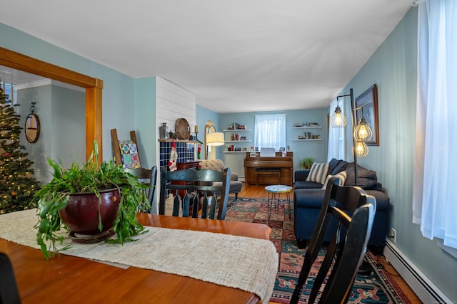 dining area featuring hardwood / wood-style floors and a baseboard heating unit