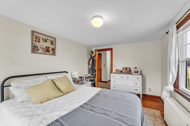 bedroom featuring radiator heating unit and light hardwood / wood-style flooring