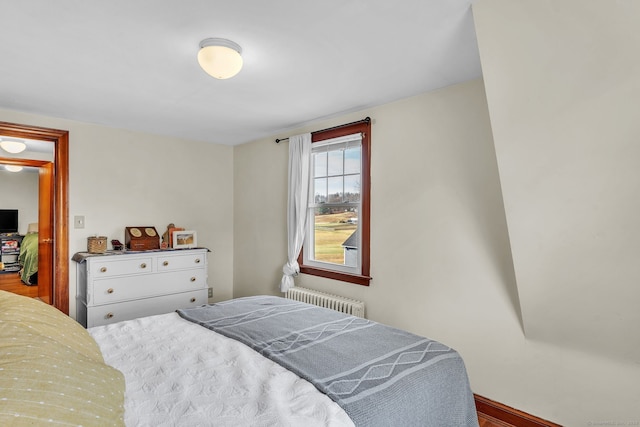 bedroom with wood-type flooring and radiator