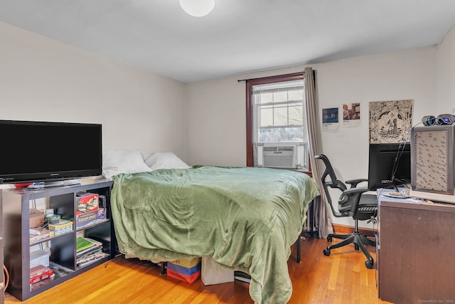 bedroom with cooling unit and wood-type flooring