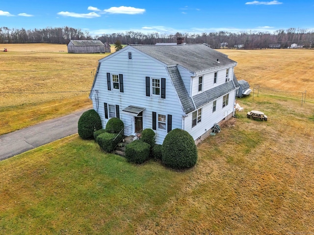 view of front of home with a rural view and a front yard