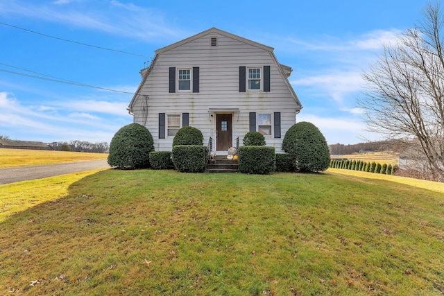 view of front of house with a front yard and a rural view