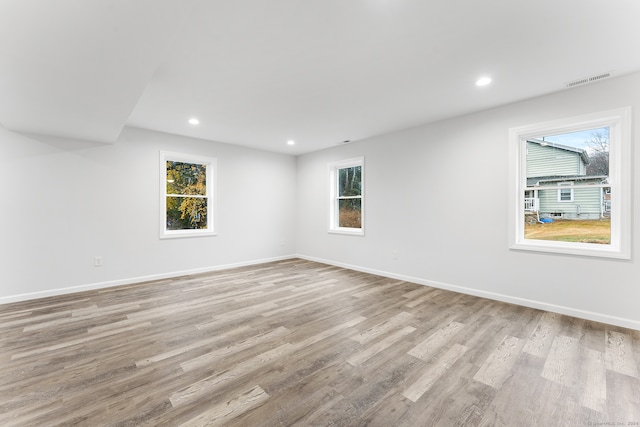 empty room with a healthy amount of sunlight and light hardwood / wood-style floors