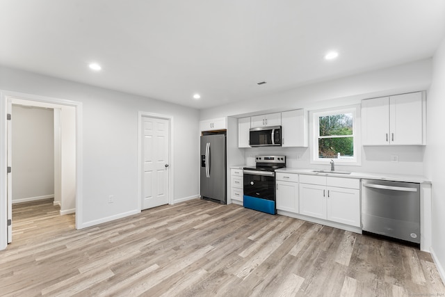 kitchen featuring sink, white cabinets, stainless steel appliances, and light hardwood / wood-style flooring