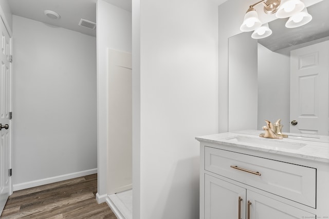 bathroom featuring hardwood / wood-style floors, vanity, and a shower