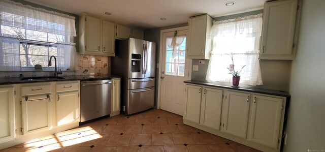 kitchen with decorative backsplash, stainless steel appliances, a wealth of natural light, and sink