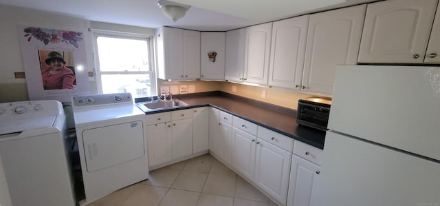 clothes washing area with light tile patterned floors, sink, and washing machine and clothes dryer