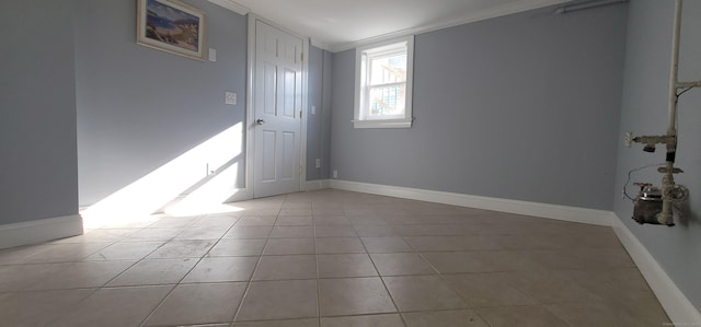 spare room featuring light tile patterned floors and crown molding