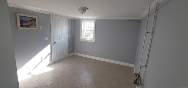 tiled empty room featuring crown molding