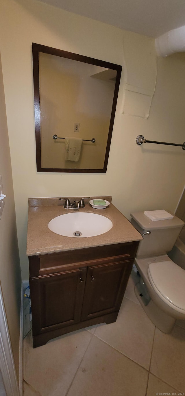 bathroom featuring tile patterned flooring, vanity, and toilet