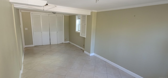 unfurnished bedroom featuring a closet, light tile patterned flooring, and ornamental molding