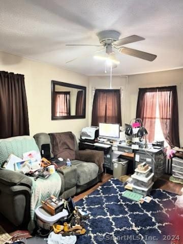 living area featuring ceiling fan and hardwood / wood-style flooring