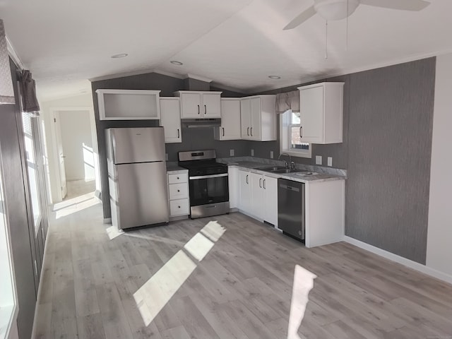 kitchen featuring appliances with stainless steel finishes, sink, light hardwood / wood-style floors, white cabinetry, and lofted ceiling