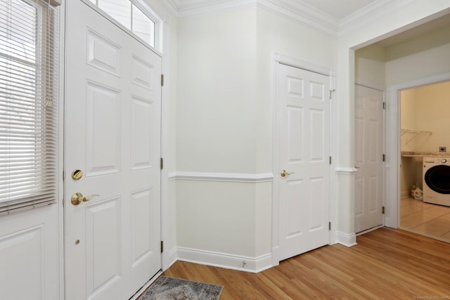 entrance foyer with light wood-type flooring, washer / clothes dryer, and ornamental molding