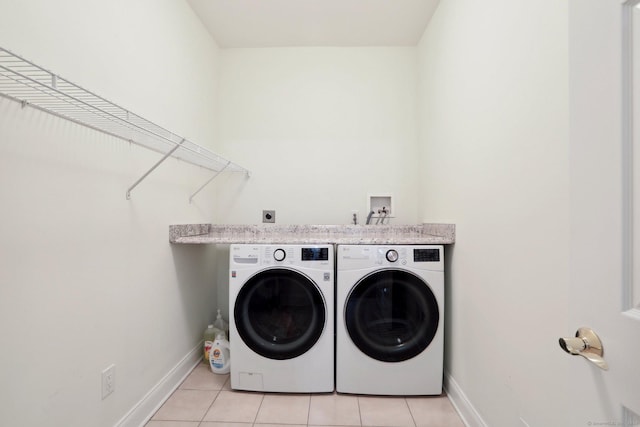 laundry area with light tile patterned floors and washer and dryer