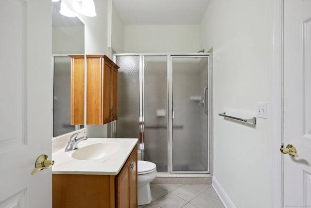 bathroom with tile patterned flooring, vanity, toilet, and a shower with shower door