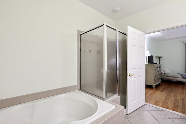 bathroom with hardwood / wood-style floors and shower with separate bathtub