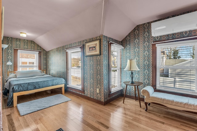 bedroom with multiple windows, vaulted ceiling, and hardwood / wood-style flooring