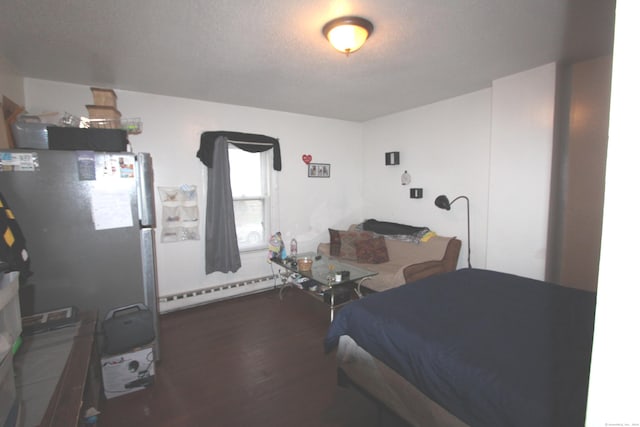 bedroom featuring dark hardwood / wood-style floors, refrigerator, a textured ceiling, and a baseboard radiator