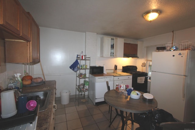 kitchen with white cabinets, light tile patterned floors, sink, and black appliances