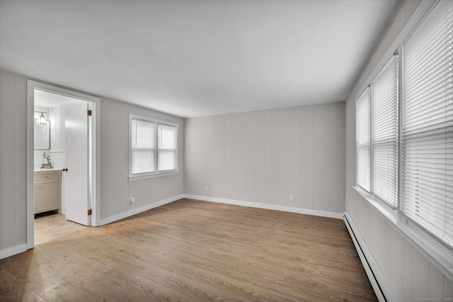 spare room featuring light hardwood / wood-style floors and a baseboard heating unit