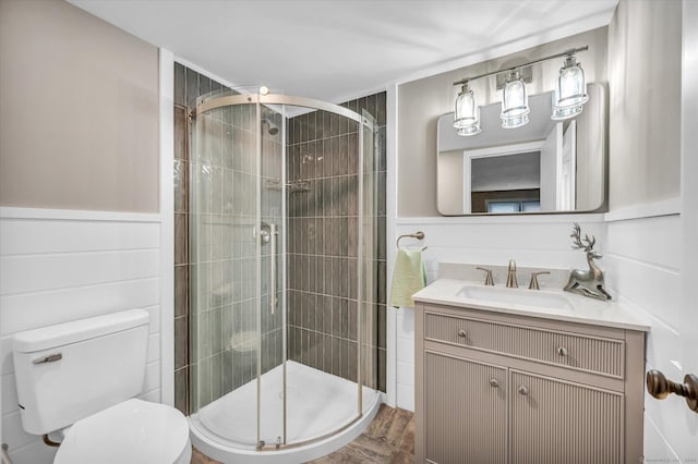 bathroom featuring hardwood / wood-style floors, vanity, toilet, and a shower with shower door