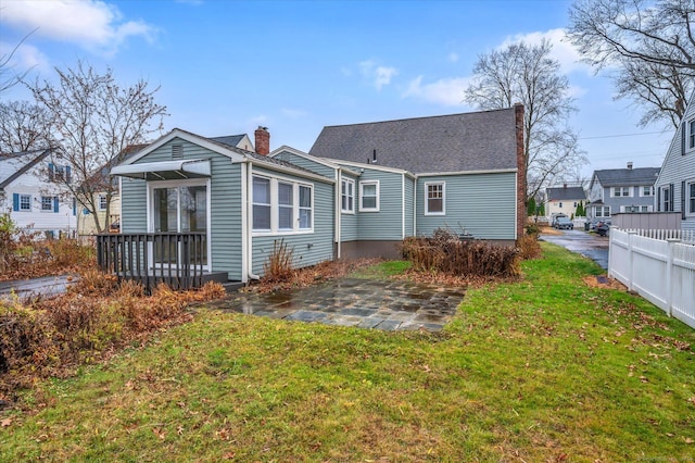 rear view of property featuring a yard and a patio area