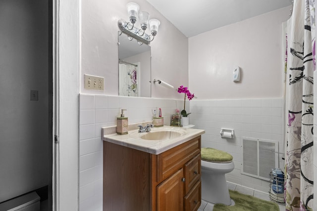 bathroom featuring tile patterned flooring, vanity, toilet, and tile walls