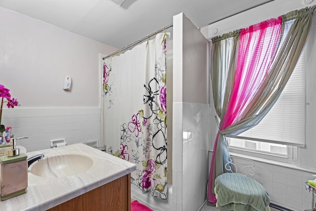 bathroom featuring vanity, shower / bathtub combination with curtain, and tile walls