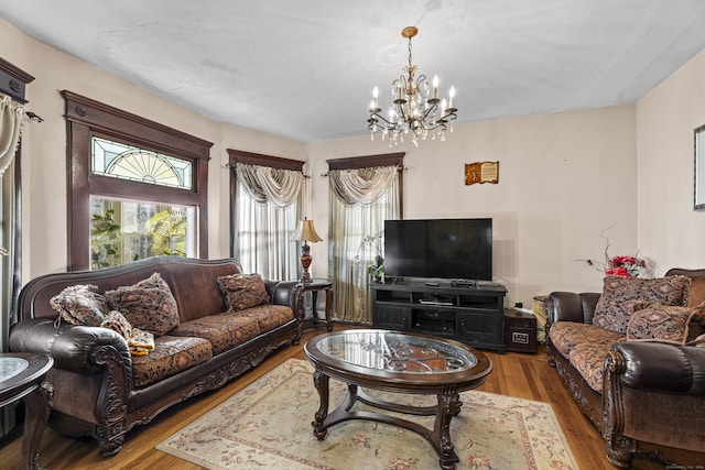 living room with light wood-type flooring and a notable chandelier