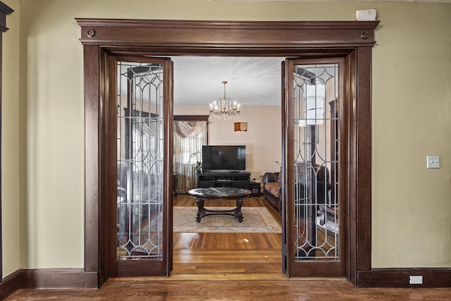 interior space featuring hardwood / wood-style floors and an inviting chandelier