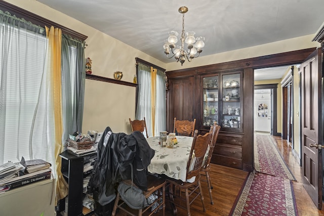 dining area featuring a chandelier, dark hardwood / wood-style floors, and a healthy amount of sunlight