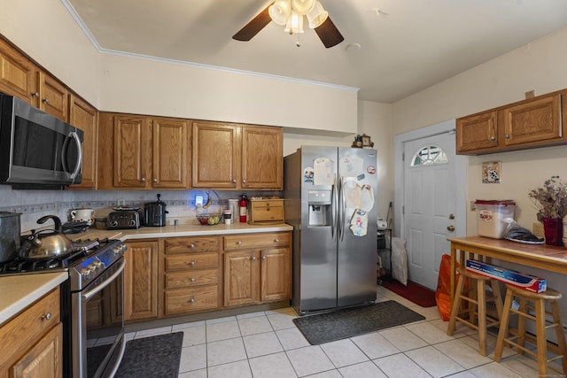 kitchen with decorative backsplash, stainless steel appliances, ceiling fan, and light tile patterned flooring