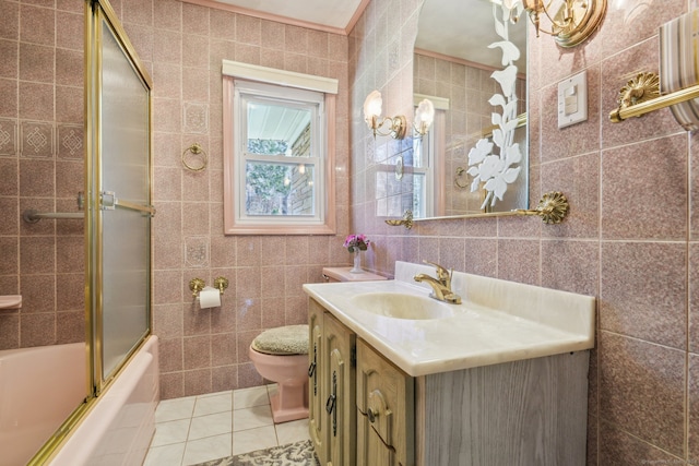 full bathroom featuring vanity, combined bath / shower with glass door, tile patterned flooring, toilet, and tile walls